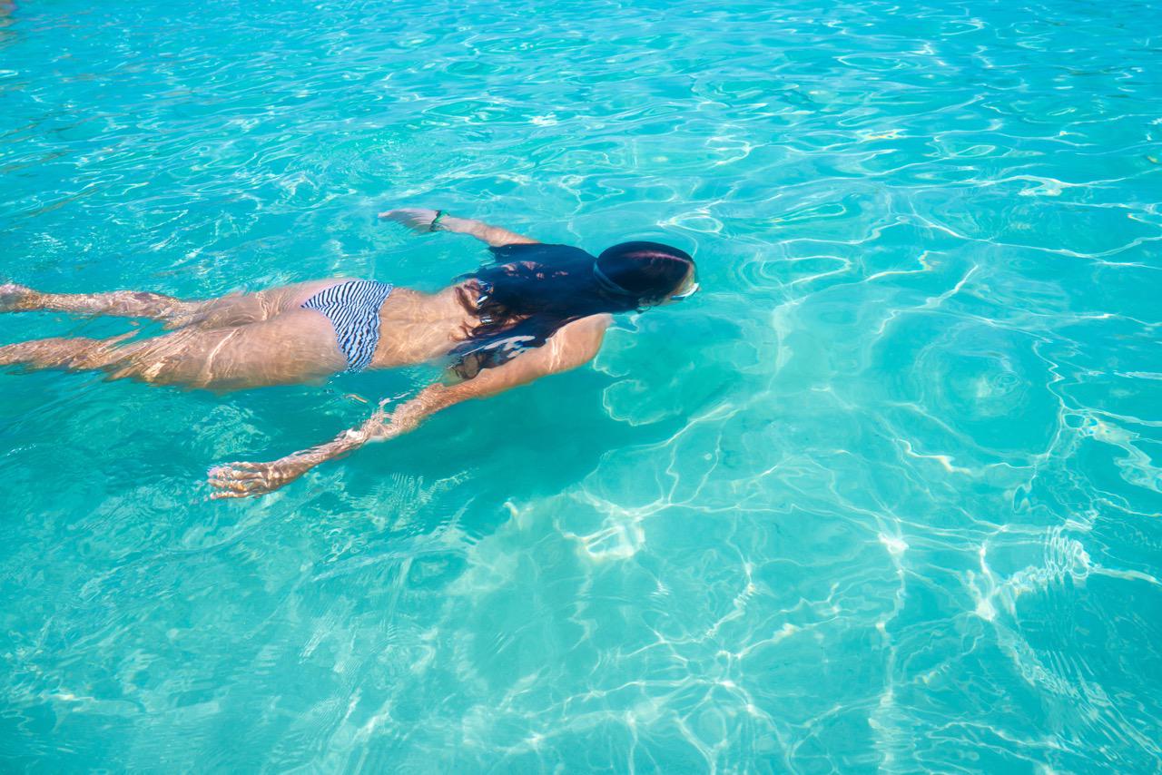 Woman swimming in the pristine Ibiza sea water